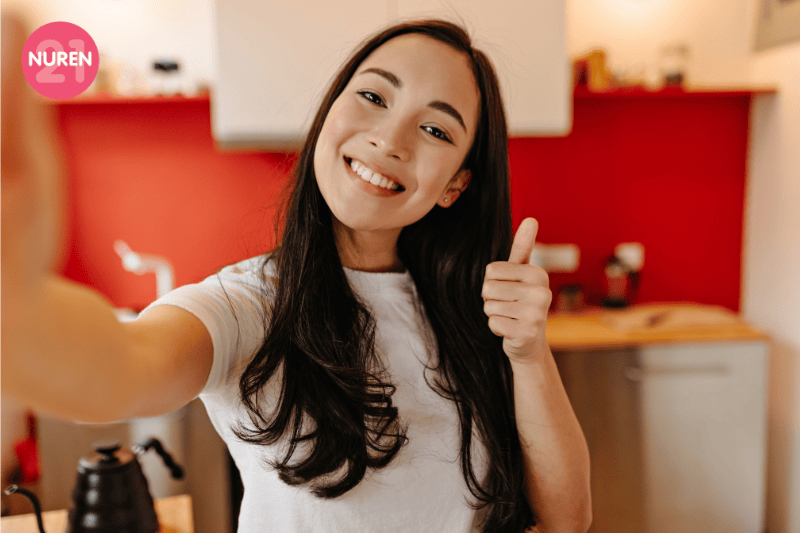 woman showing thumbs up while taking a selfie