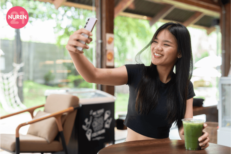 young girl taking selfie with her matcha in a cafe feeling happy and self sufficient