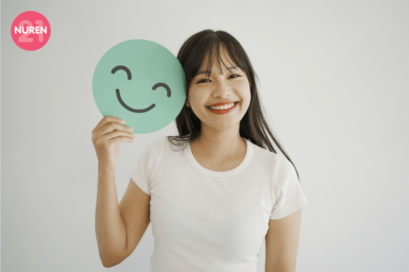 young girl holding a smiley face showcasing importance of mental health