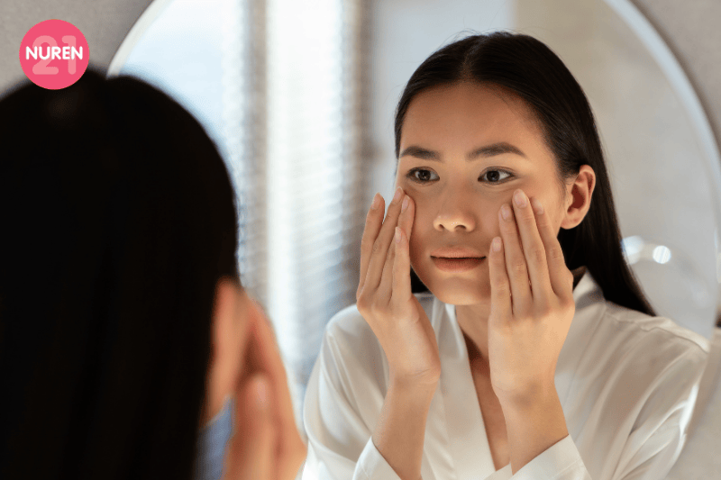young girl looking into the mirror concerned with her skin condition