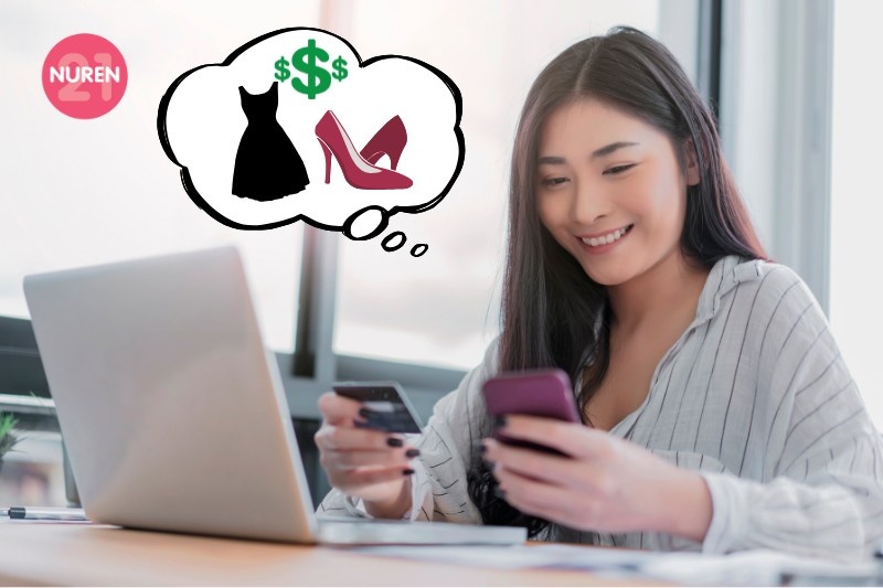 A woman shopping online on her laptop with her phone and credit card