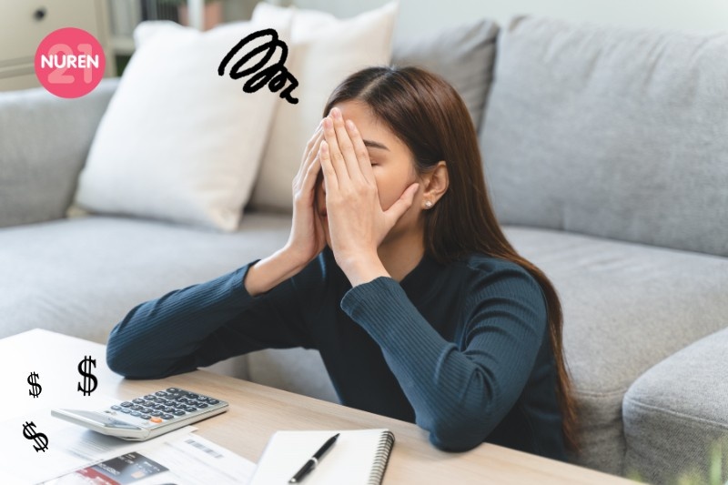 An exasperated woman over a notebook and calculator
