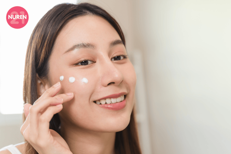 image of woman putting on cream on face