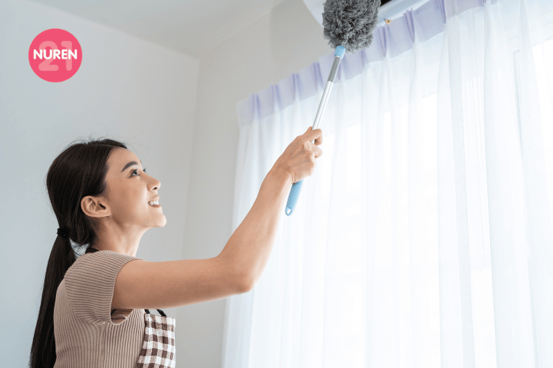 woman using extendable duster to clean the aircon