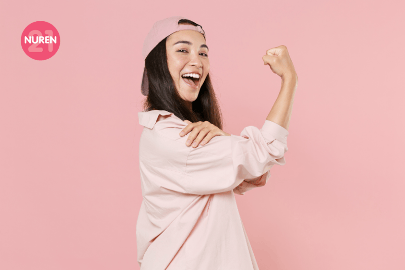 women in backward cap in isolated pink background showing strength