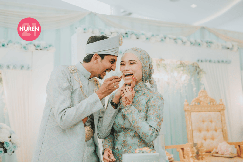 couple photo of newly married malay bride and groom feeding each other cake