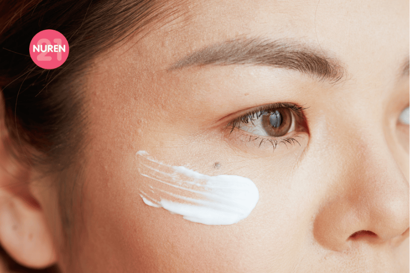 asian woman showing swipe of eye cream