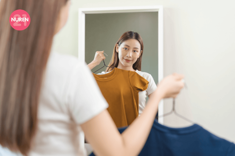A woman in the mirror choosing what to wear