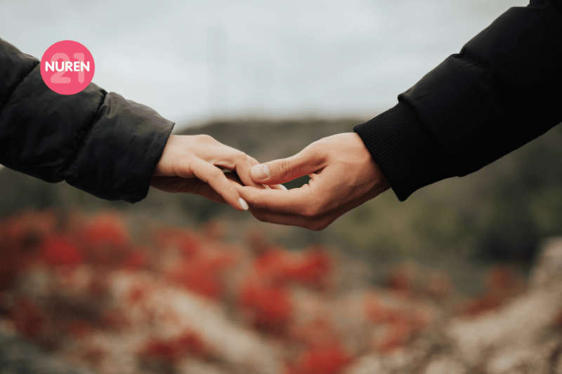 Close up of arms of young couple in love holding hands