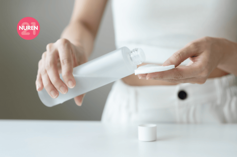 women pouring some toner on her cotton pad