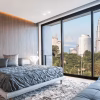 Modern and contemporary bedroom with white ceiling and wood accents with views of Kuala Lumpur skyline. Condo or Hotel accommodation.