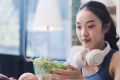 woman with headphone eating healthy meals active lifestyle