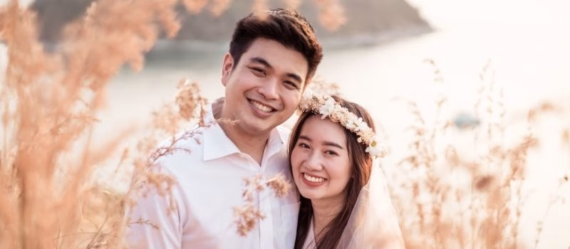 Happy young Asian couple in love having a good time with sea background