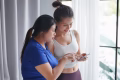Asian women friends use phone after exercise.