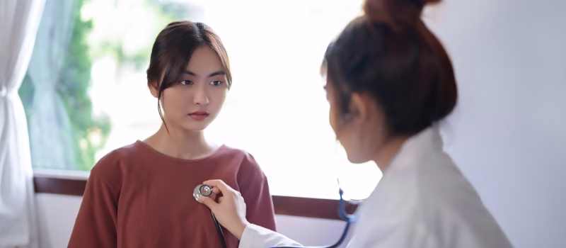 Asian psychologist women listening heartbeat of patient with stethoscope and giving counseling about mental health therapy while female patient stress and anxiety with psychological health problem.