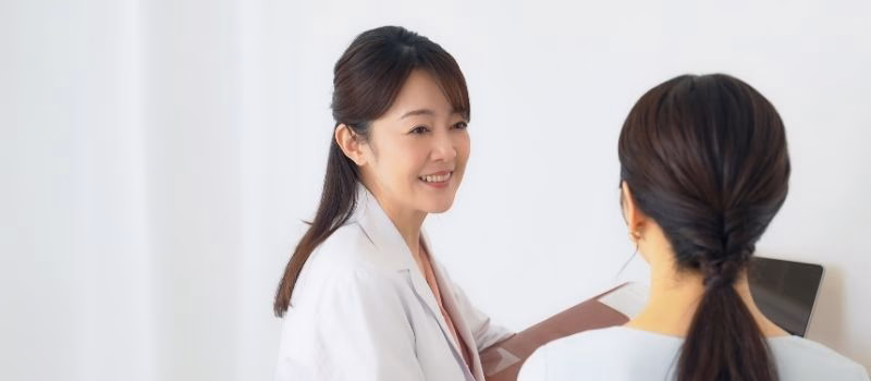 Doctor explaining to female patient undergoing examination. Interview at the hospital.