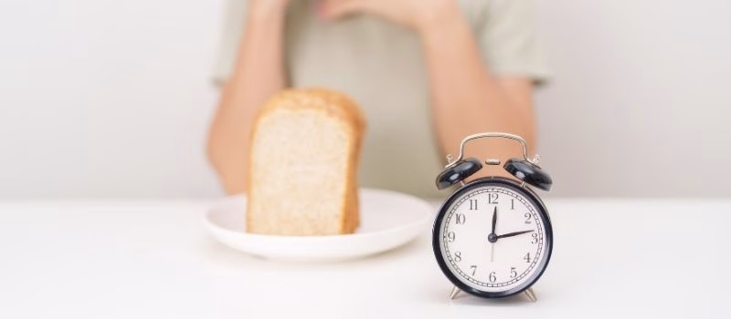 hungry woman with whole wheat bread and clock. concept of intermittent fasting, IF, meal, Time to eat, choosing healthy carbohydrates, balanced diet and weight loss management, Nutrition schedule