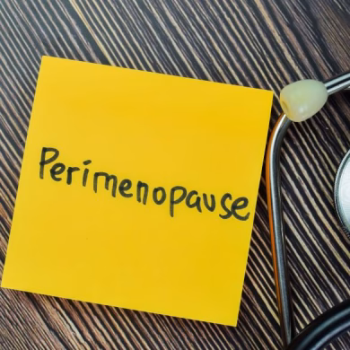 Concept of Perimenopause write on sticky notes with stethoscope isolated on Wooden Table.